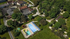 Vista aérea de una zona residencial con piscina, casas y una carretera.