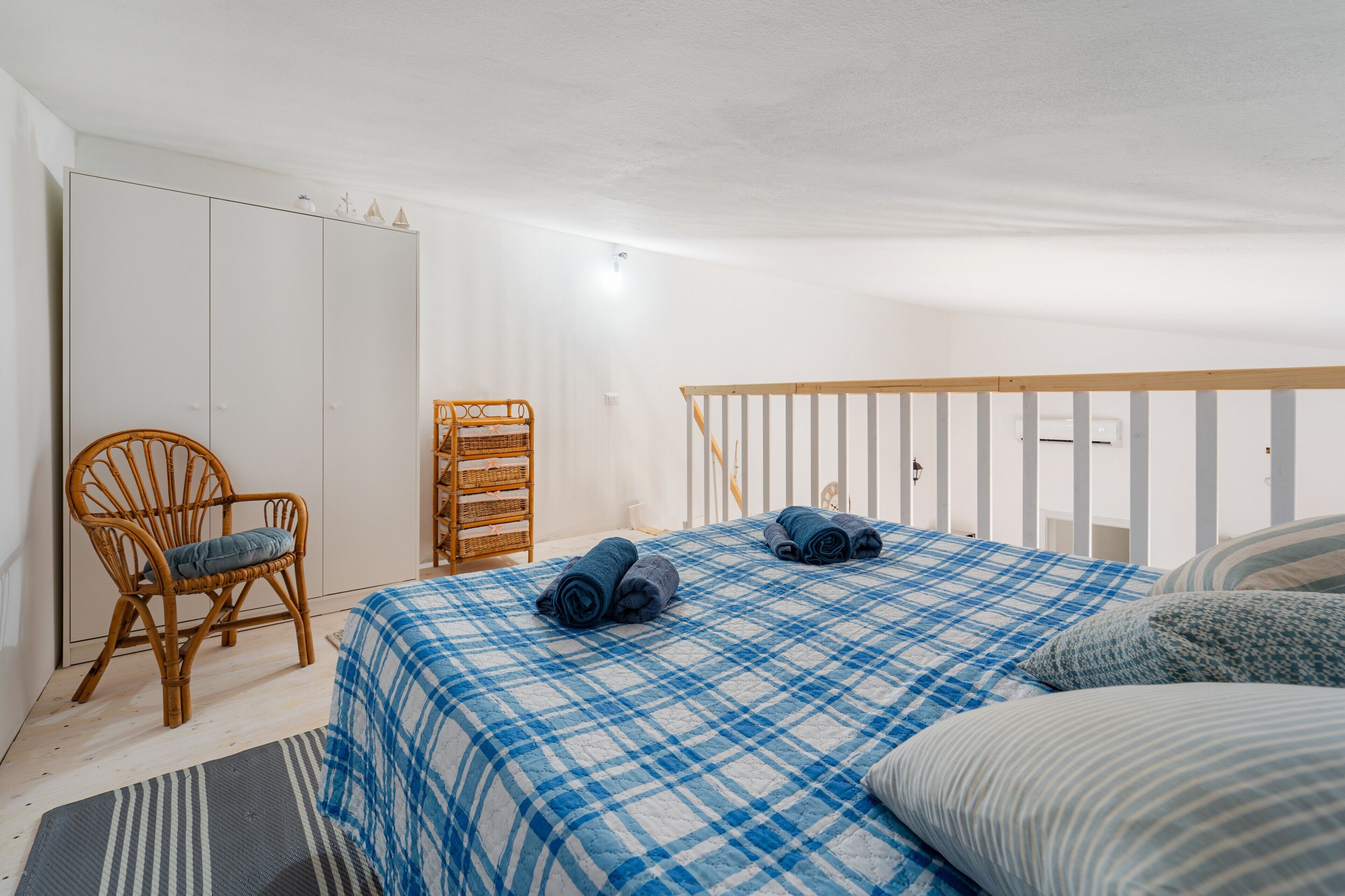 Un dormitorio con cama, una silla, un armario y una cuna.