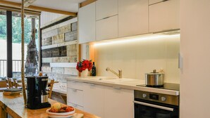 A modern kitchen with a wooden countertop, stainless steel appliances, and a large window. - Le Fayard Loft – Character Apartment in Renovated Farmhouse, Hot Tub, Mountain Views (Aillon-le-Jeune)