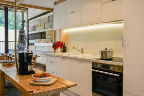 Una cucina moderna con un piano di lavoro in legno, elettrodomestici in acciaio inossidabile e un'ampia finestra.