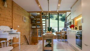 A wooden interior with a kitchen area, dining table, and chairs. - Le Fayard Loft – Character Apartment in Renovated Farmhouse, Hot Tub, Mountain Views (Aillon-le-Jeune)
