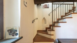 A staircase with wooden steps and a metal railing, leading to a landing with a picture frame and a small decorative alcove. - Villa 'Bianca Luce' with Private Pool, Private Terrace and Wi-Fi (Santa Luce)