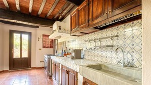 A kitchen with wooden cabinets, a tiled backsplash, and a large sink. - Villa 'Bianca Luce' with Private Pool, Private Terrace and Wi-Fi (Santa Luce)