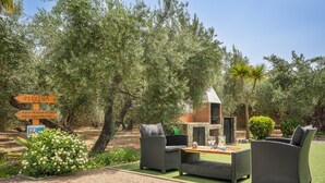 Outdoor seating with a sign indicating a pool direction. - Holiday Home 'Benizarte' with Mountain View, Wi-Fi and Air Conditioning (Órgiva)
