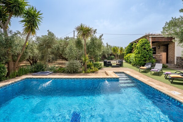 A swimming pool with lounge chairs and a patio area.