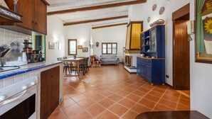 A kitchen with wooden cabinets, a tiled backsplash, and a dining area with a table and chairs.