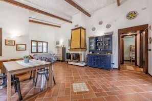 Un'ampia cucina con isola centrale, piano cottura integrato e un armadietto blu con ante in vetro.
