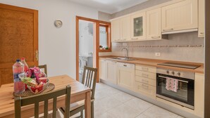 Een keuken met houten kastjes, een spoelbak en een oven.