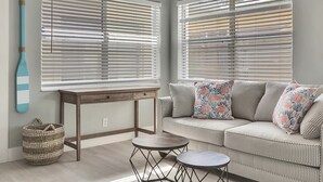 A living room with a sofa, a small round table, and a wooden side table.