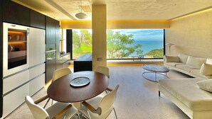 Una cocina moderna con comedor, sofá y vista al océano.