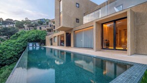 Una casa moderna con piscina, amplios ventanales y vistas del entorno.