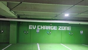 Ein Bereich zum Aufladen von Elektrofahrzeugen mit mehreren Ladestationen und deutlich markierten Stellplätzen.