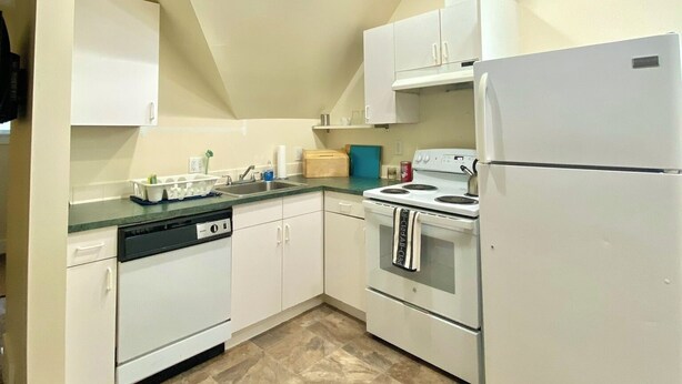 A kitchen with white cabinets, a dishwasher, a stove, and a refrigerator. - Charming 1-bedroom apartment close to downtown Seattle! (Seattle)