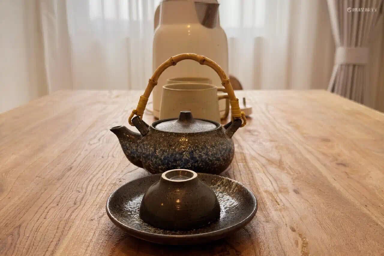 Un juego de té tradicional sobre una mesa de madera, con una tetera de cerámica y una taza a juego.