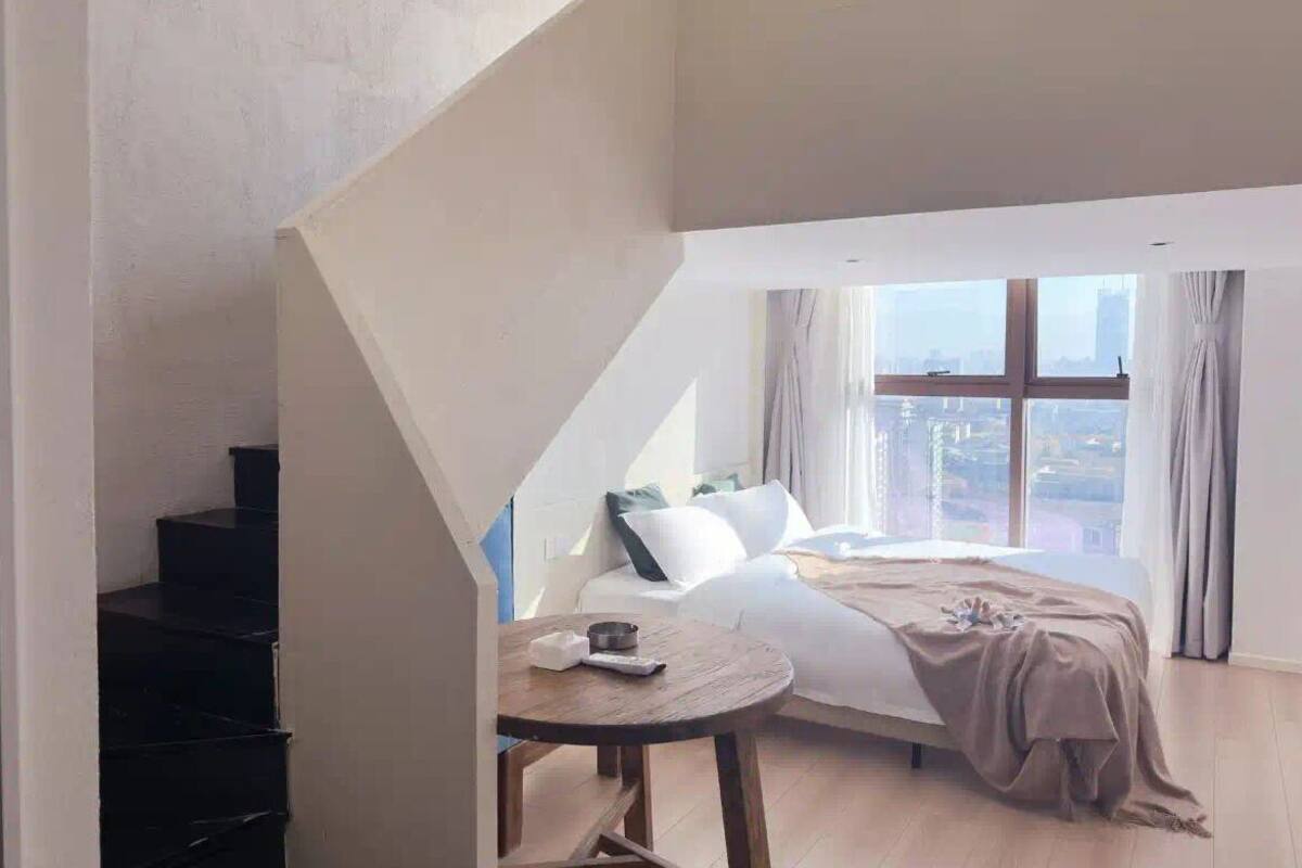 Una camera da letto con un letto, un tavolo e una scala.