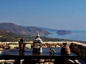 A table with a view of a mountainous landscape and a body of water.