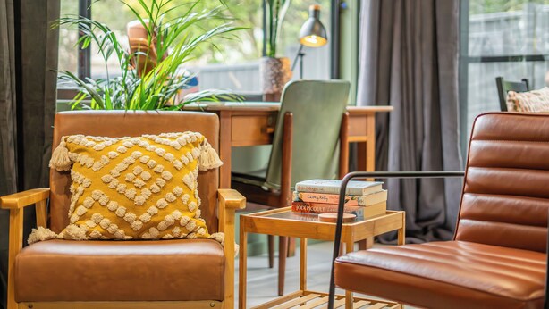 A cozy reading nook with leather chairs, a small wooden table, and a bookshelf. - Stunning Studio in Berkeley - Entire Private Guesthouse + No Shared Spaces (Berkeley)