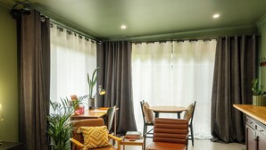 A cozy room with a bed, a desk, a chair, a small table, and a dining table. - Stunning Studio in Berkeley - Entire Private Guesthouse + No Shared Spaces (Berkeley)
