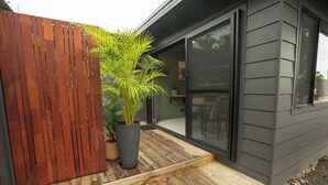A modern house with a wooden deck, a potted plant, and a sliding glass door leading to a room. - Stunning Studio in Berkeley - Entire Private Guesthouse + No Shared Spaces (Berkeley)