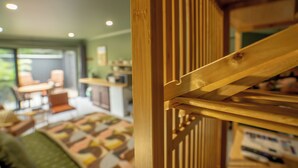 A wooden staircase with a railing, leading to a room with a patterned floor and a view of a dining area with chairs and a table. - Stunning Studio in Berkeley - Entire Private Guesthouse + No Shared Spaces (Berkeley)