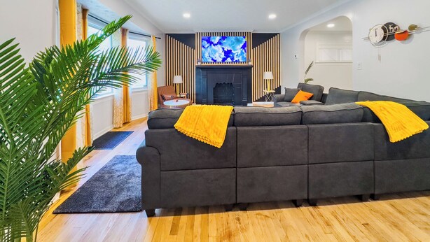 A modern living room with a grey sofa, a fireplace, and a TV.