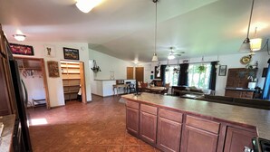 Una cocina amplia con una isla grande, armarios de madera y un comedor con sillas y mesa.
