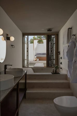 A modern bathroom with two sinks, a large mirror, and a view of a balcony with a bed. - Casa Meraki Mérida - Paseo de Montejo (Centro)