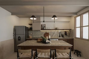 A modern kitchen with a central island, granite countertops, a stainless steel refrigerator, and pendant lighting.