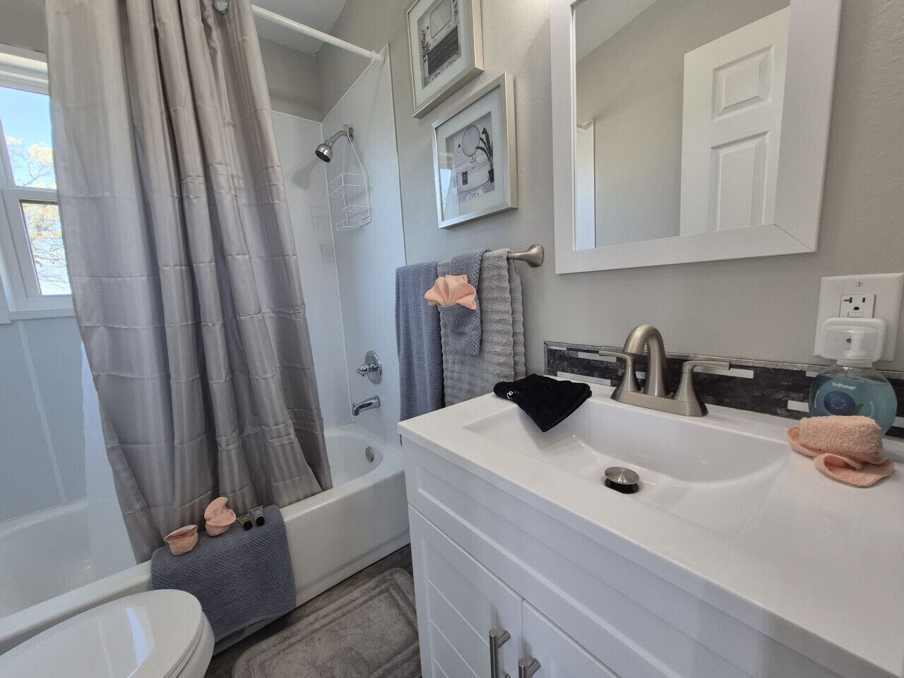 Une salle de bain avec une baignoire, un lavabo, un miroir et un porte-serviettes.