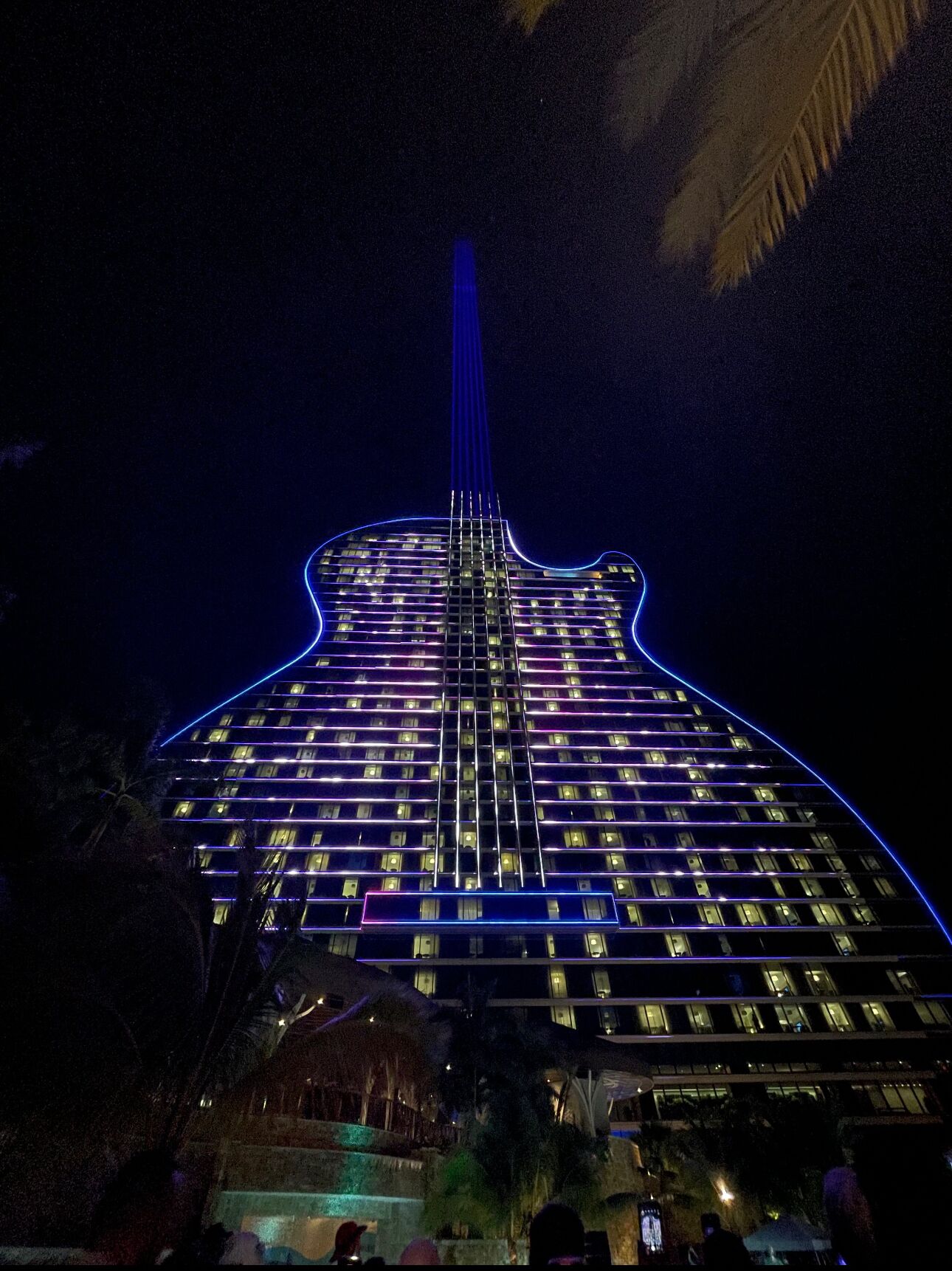 Un bâtiment illuminé de lumières bleues, formant la silhouette d’une guitare.