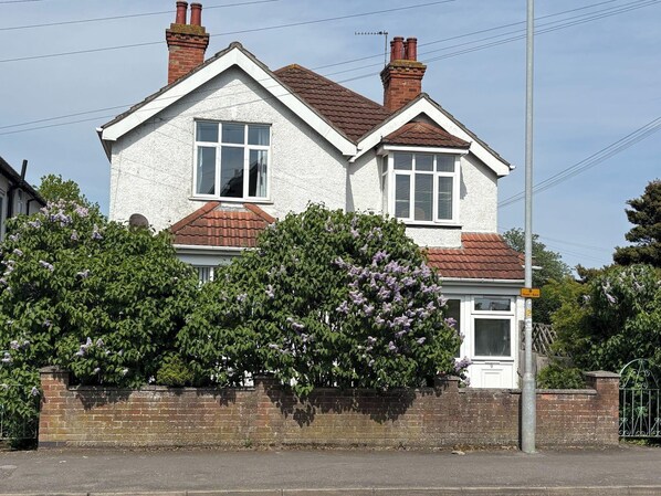 A two-story house with a brick facade, white window frames, and a red-tiled roof. - 5 Bed Villa - Sleeps 10 - Pets - Garden - Parking (Skegness)