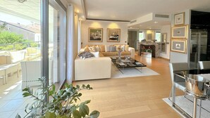 A spacious living area with a sofa, coffee table, and a dining area with a modern kitchen in the background. - Luxury 2-Bedroom Apartment - Rue d'Antibes, Cannes (Cannes)