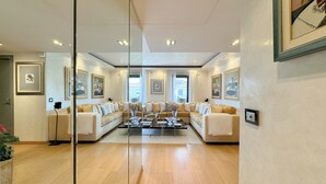 A spacious living room with a large sectional sofa, a glass coffee table, and framed artwork on the walls. - Luxury 2-Bedroom Apartment - Rue d'Antibes, Cannes (Cannes)