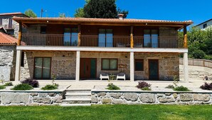 A two-story stone house with a balcony, a pool, and a garden. - Casa do Sol e Vinho: Breathtaking views & oasis of peace villa (Ourilhe)