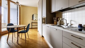 Une cuisine moderne avec un coin repas, un four à micro-ondes et un évier.