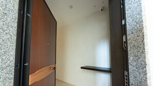A hallway with a wooden door, a white wall, and a granite countertop. - GuestHost –La Rosa dei Venti, Borea Apt by the sea (Trani)