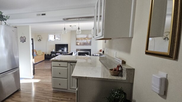 Een moderne keuken met roestvrijstalen apparatuur, een centraal eiland en een eethoek met een televisie.