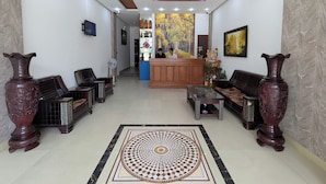 A lobby with a reception desk, seating area, and decorative vases. - LE'S HOTEL & APARTMENT (Da Nang)