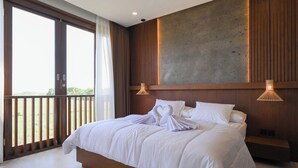 Ein modernes Hotelzimmer mit einem großen Bett, einem Holzkopfschild und einem Balkon mit Blick.