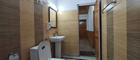 A compact bathroom with a toilet, sink, and mirror.