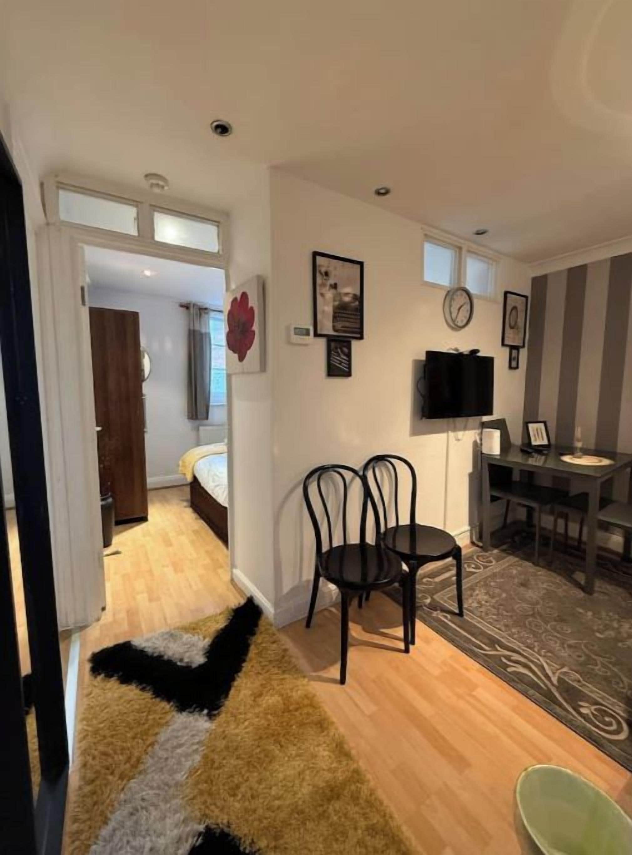 Un salon moderne avec un canapé, une table basse et un téléviseur. Il y a également un coin repas avec une table et des chaises.