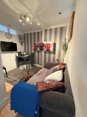 Relax in this stylish space with a sofa, flat-screen TV, and a small table for work or dining.
