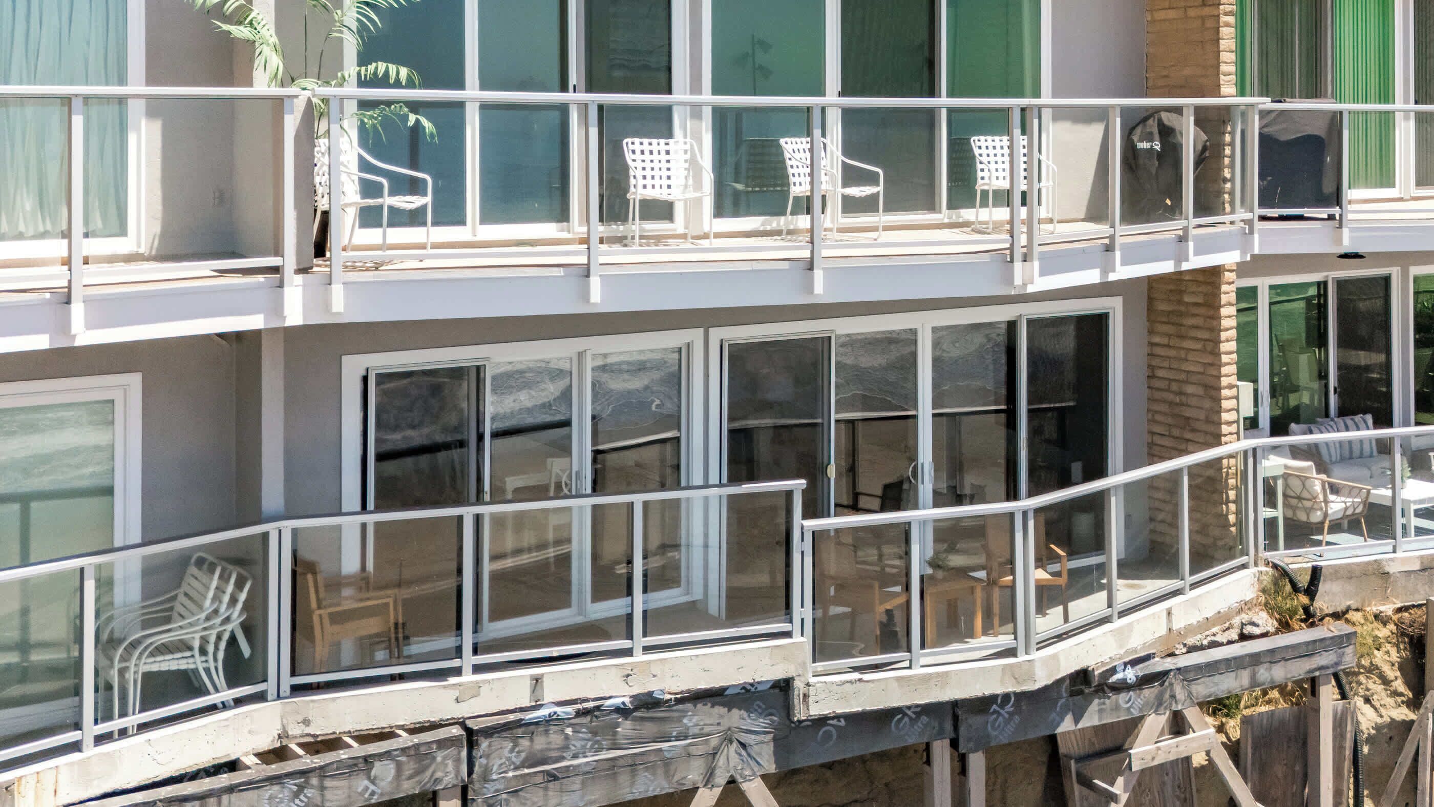 A multi-story building with balconies, large windows, and outdoor seating areas.