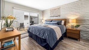 A bedroom with a bed, bedside tables, a desk, and a chair. - 2 bedroom Rio Del Mar Apt - Stunning Ocean Views (Aptos)