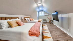 A bedroom with a bed, pillows, a blanket, a TV, and a window. - Dundee Delight 3Br2Ba sleeps 9, central Omaha, heart of historical neighborhood (Omaha)