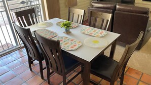 A dining table with floral placemats, a small potted plant, and matching coasters. - 3-bedroom building in enjoyable Tucson with AC, WiFi (Tucson)
