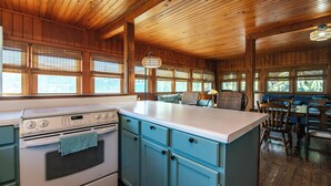 Una cocina con techo y armarios de madera, estufa blanca y encimera azul.