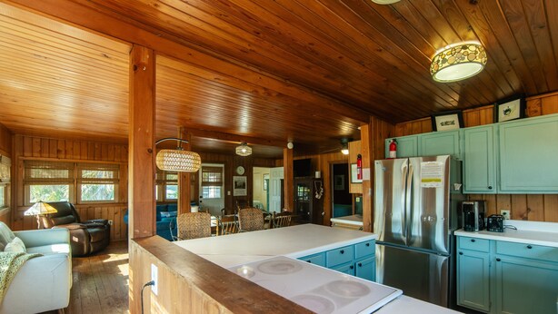 Interior de una cabaña de madera con cocina, comedor y sala de estar.