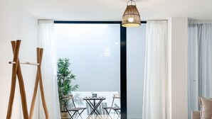 A modern living room with a balcony, a wooden easel, and a hanging light fixture.