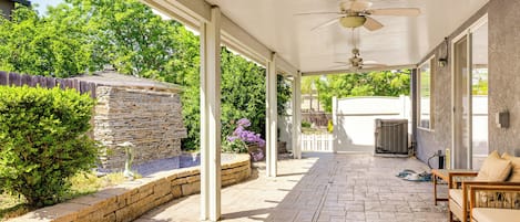 Relax in a serene garden setting with a comfortable seating area and ceiling fan.